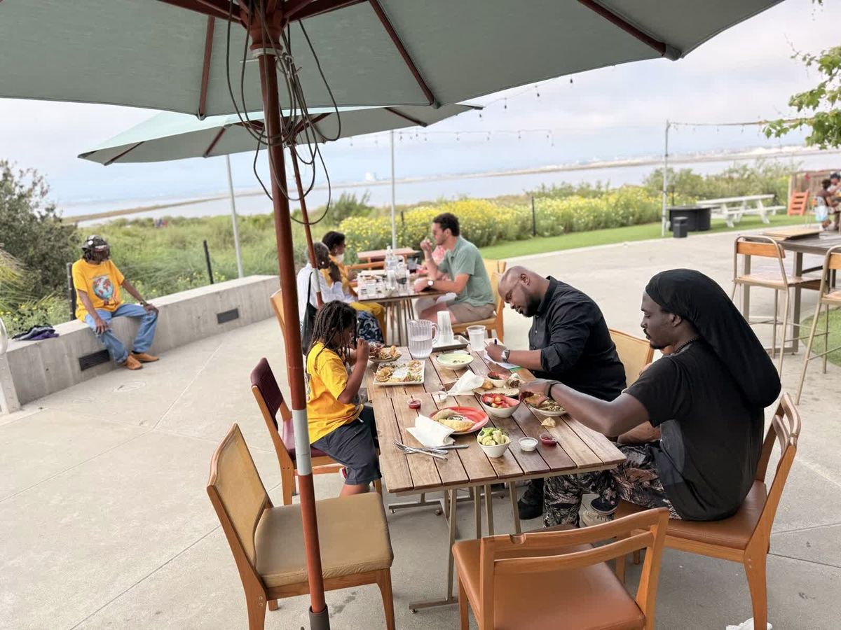 Neighbors seated around a patio table in conversation at CCE's community listening forum.
